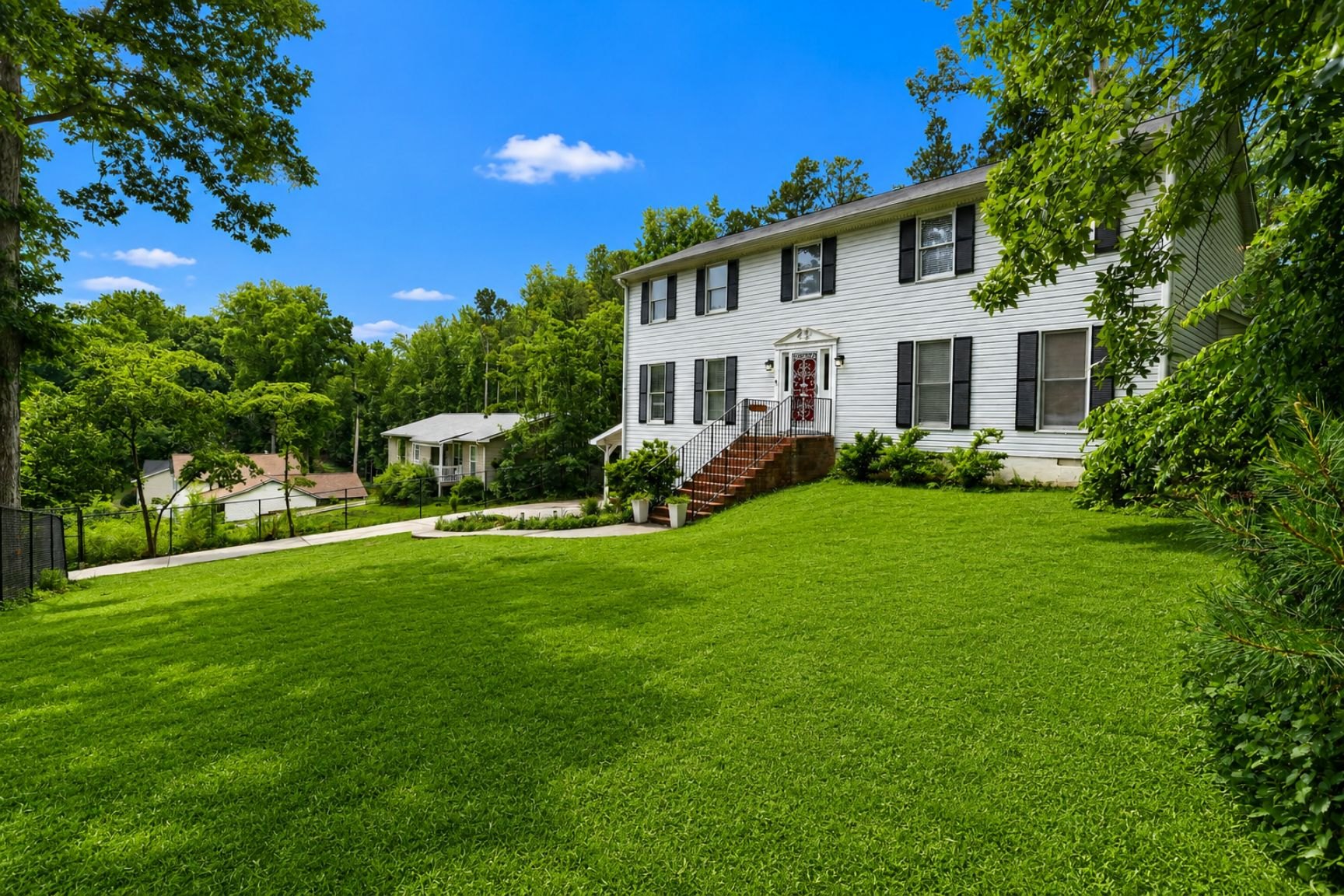 Front exterior of 305 Saint Patrick Drive SW with lawn and mature trees